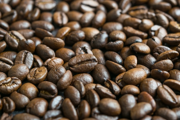 Granos de café tostados en la mesa de madera, Fondo de alimentos