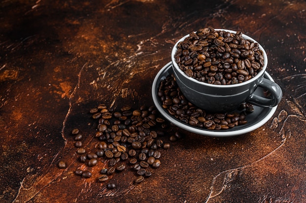 Granos de café tostados oscuros en una taza.