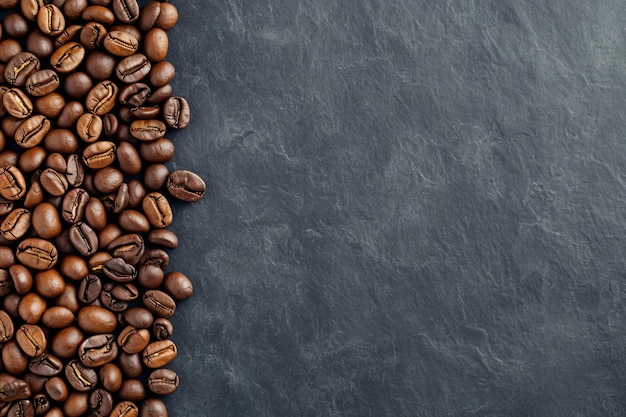 Granos de café tostados de primera calidad en un estandarte de fondo negro para los amantes del café y los baristas