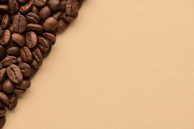 Granos de café tostados sobre fondo beige con espacio de copia. Cerrar vista superior.