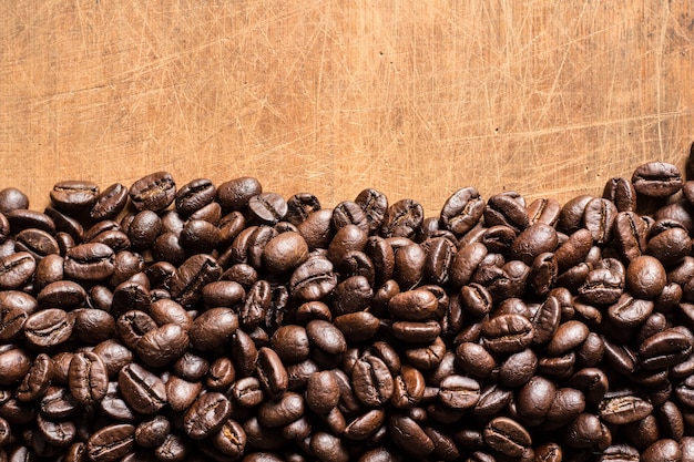 Granos de café tostados sobre fondo de madera vieja