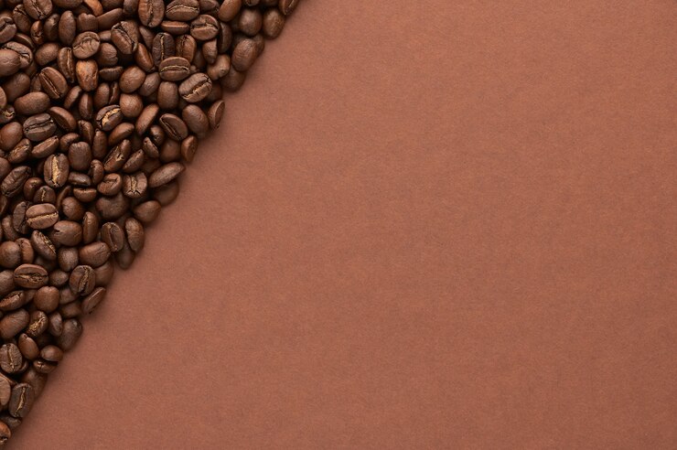 Granos de café tostados sobre fondo marrón con espacio de copia vista superior de cerca