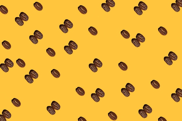 Granos de café tostados sobre un patrón de fondo amarillo