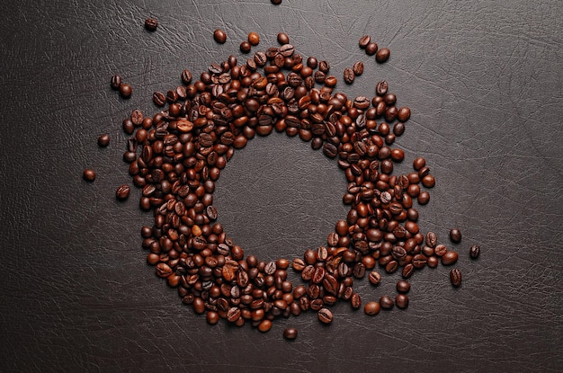 Granos de café tostados en superficie con textura oscura Espacio de copia