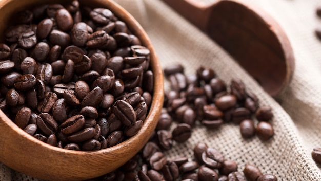 Granos de café tostados en un tazón de madera. Granos de café aromáticos