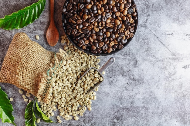 Granos de café verdes crudos sin tostar en sacos marrones y granos de café tostados en una sartén.