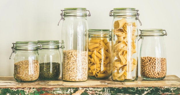 Granos de cereales crudos frijoles y pasta en la composición de toda la mesa