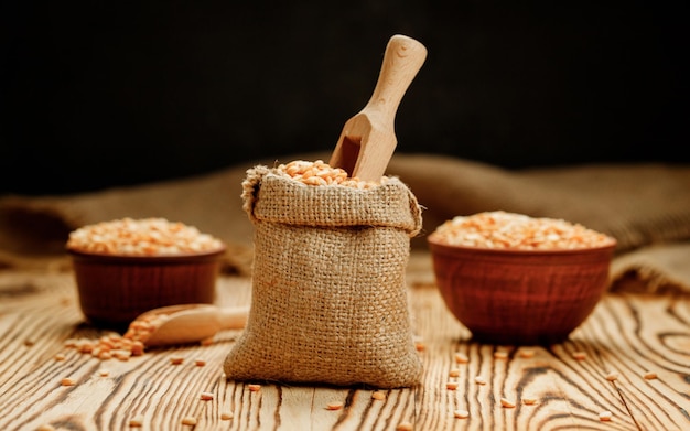 Granos de guisantes en tazones y bolsas sobre un fondo de madera Foto de alta calidad