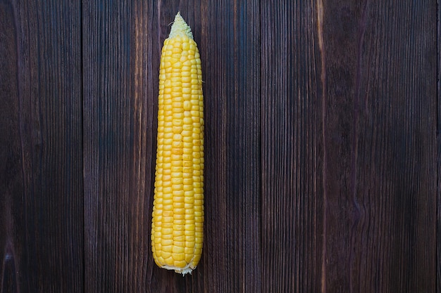 Granos de maíz maduro sobre fondo de madera