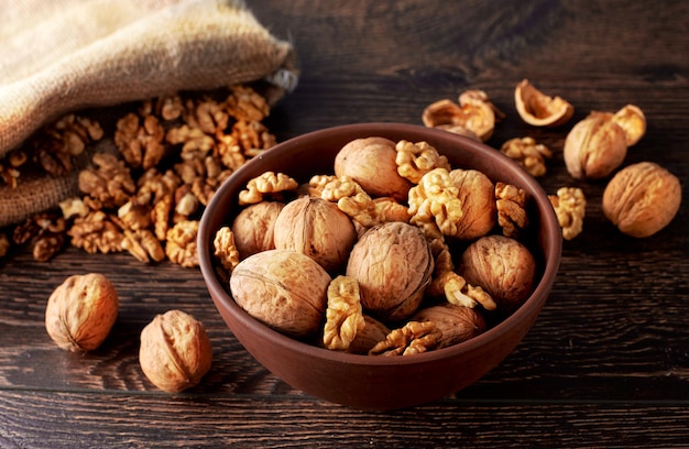 Granos de nueces y nueces enteras en rústica mesa de madera antigua