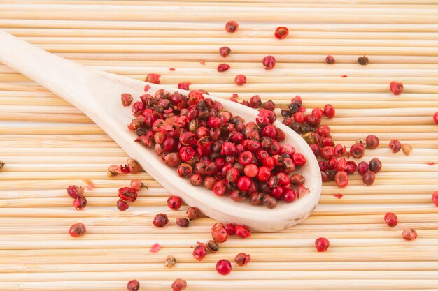 Granos de pimienta roja en una tabla de cortar