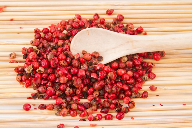 Granos de pimienta roja en una tabla de cortar