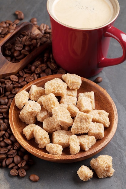 Granos de la taza de café y azúcar moreno