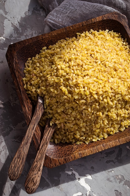 Granos de trigo bulgur en un tazón de madera