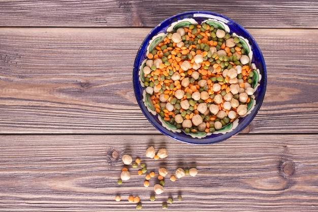 Grão de bico, lentilha laranja e mung em uma tigela de madeira