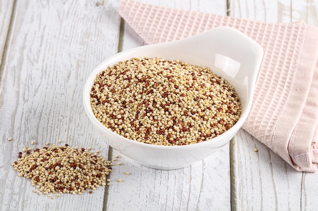 Foto grão de cereal de quinoa seca crua na tigela