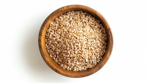 Foto grãos de arroz castanho em tigela de madeira isolados em fundo branco vista superior