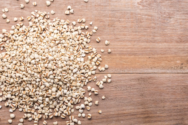 Grãos de arroz ou milho painço vista superior sobre fundo de mesa de madeira