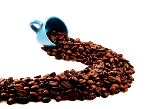 Grãos de café caindo da xícara contra um fundo branco