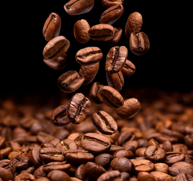 Grãos de café caindo em fundo escuro