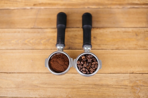 Grãos de café de vista superior em filtro sem fundo com xícara de café preto na mesa de madeira Foco seletivo Grãos de café em um filtro sem fundo em uma mesa de madeira