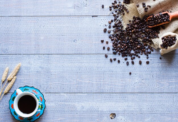 Grãos de café e café com outros componentes em fundo de madeira diferente. Espaço livre para texto