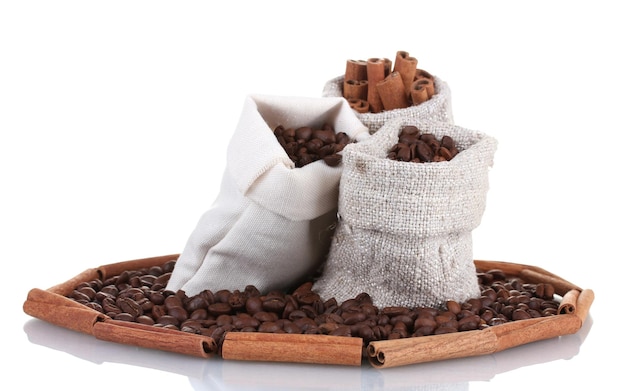 Foto grãos de café e canela em sacos de lona isolados em branco