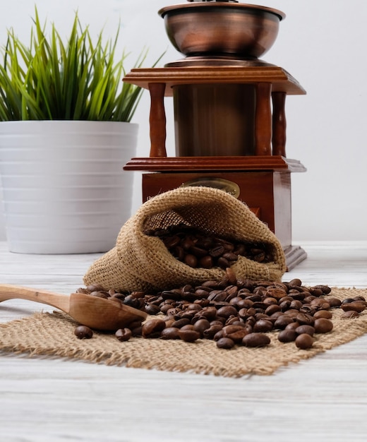 Foto grãos de café e moedor de café em cima da mesa