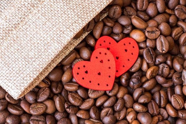 Grãos de café e um coração perto de uma bolsa de lona