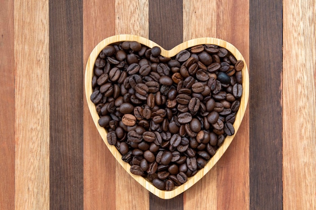 grãos de café em bandeja em forma de coração representando o amor pelo café