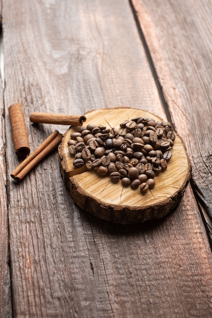 Grãos de café em forma de coração na mesa de madeira vintage