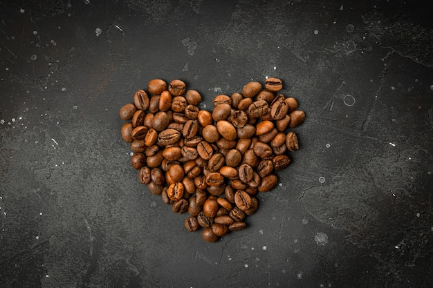 Grãos de café em fundo cinza escuro, o conceito de amor do café em forma de coração.