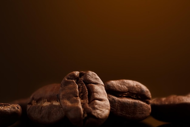 Grãos de café em um fundo escuro com um destaque amarelo no fundo closeup de grãos de café para uma cafeteria