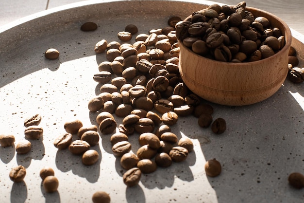 Grãos de café em uma xícara de madeira.