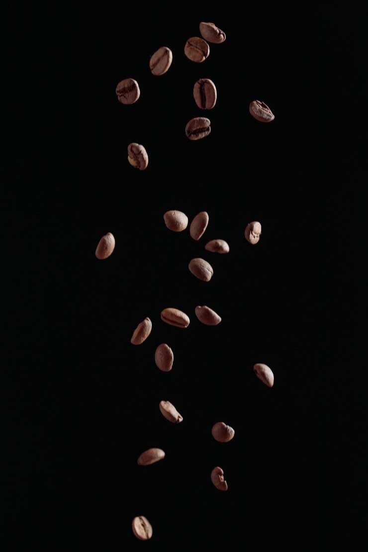 Grãos de café em voo sobre um fundo escuro