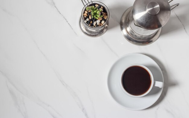 Grãos de café espalhados e xícara de café expresso no pano de fundo de mármore