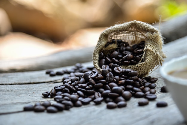 grãos de café espalhados pelo pequeno saco