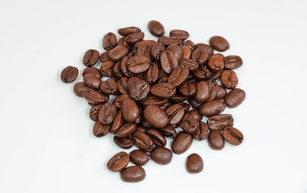Grãos de café isolados em uma superfície branca.