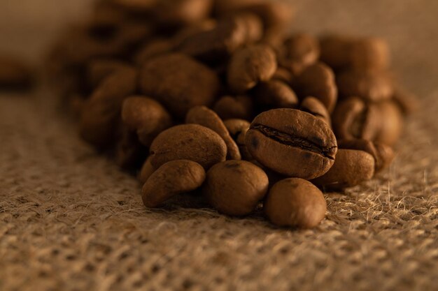 Foto grãos de café macro em uma toalha de mesa bege