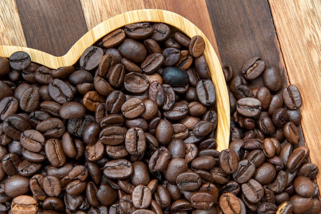 Grãos de café na bandeja em forma de coração, representando o amor pelo café