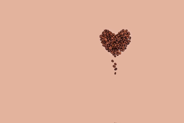 Foto grãos de café na forma de um coração em um fundo bege.