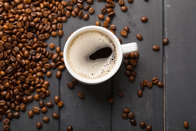 Grãos de café pretos em fundo preto