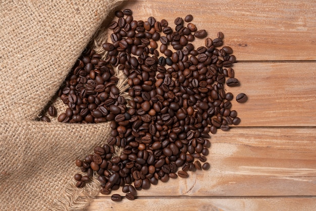 grãos de café robusta no fundo da mesa de madeira