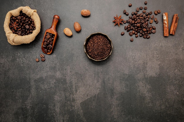 Grãos de café torrados com pó de café e ingredientes saborosos para fazer uma saborosa configuração de café em fundo escuro de pedra