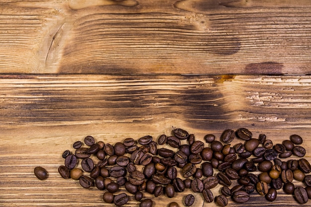 Grãos de café torrados em fundo de madeira