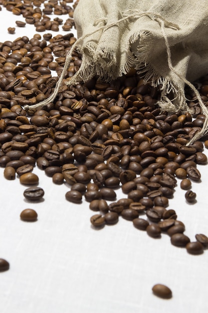 Grãos de café torrados em um saco. fundo branco