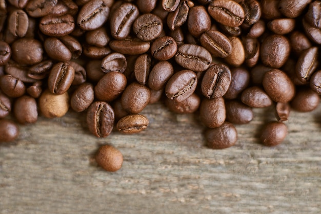 Grãos de café torrados no fundo de madeira rústico. ingredientes alimentares, vista superior