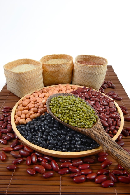 Grãos de cereais e sementes de feijão e arroz branco útil para a saúde em colheres de madeira.