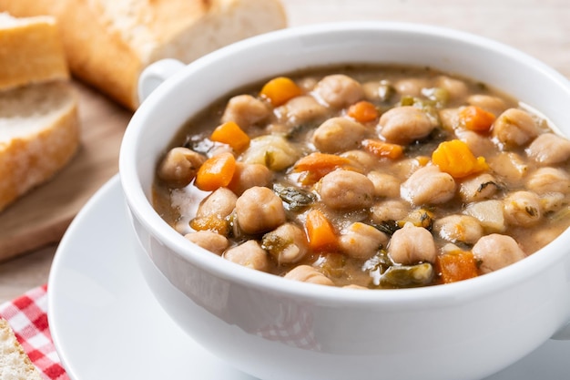 Grãos de grão-de-bico com legumes em mesa de madeira