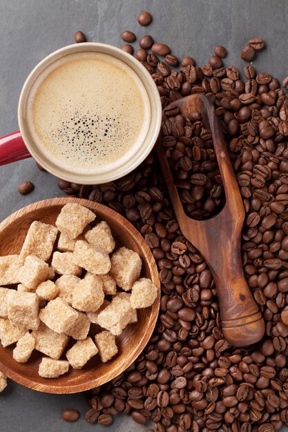 Grãos de xícara de café e açúcar mascavo na mesa de pedra